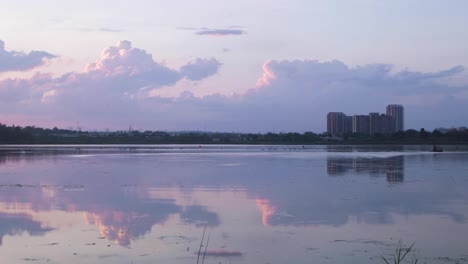 Pink-Clouds-Reflection-Over-Man-in-Boat-Timelapse
