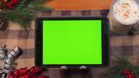 Close-up-static-shot-of-a-mobile-device-with-a-green-chroma-matte-screen-in-a-holiday-setting