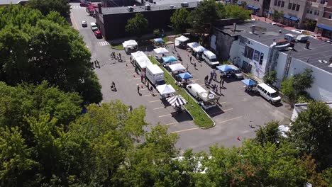 Shoppers-visit-tents-at-a-farmers'-market-in-a-parking-lot