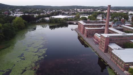 A-historic-watch-factory-and-smokestack-beside-the-Charles-River-in-Waltham,-Massachusetts