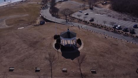 Circling-over-the-pavilion-at-Stage-Fort-Park-in-Gloucester,-Massachusetts