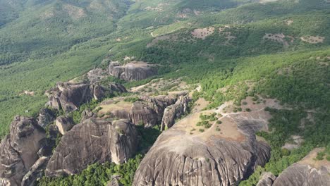 Aerial-walkthrough-over-a-unique-area-at-Thessaly,-Greece,-full-of-impressive-and-massive-rock-formations-covered-by-vegetation