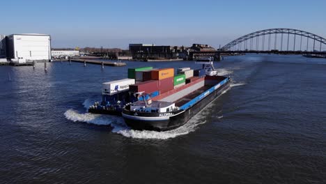 Alorba-Barge-With-Bulk-Of-Intermodal-Containers-Sailing-At-Noord-River-With-Arch-Bridge-In-Background