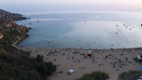 Aerial-panorama-view-of-Golden-Bay-beach-with-people-at-sunset,Malta