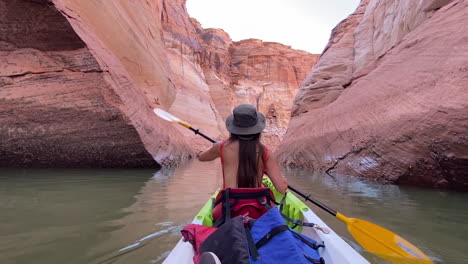 Back-view-of-female-with-paddle-kayaking-in-slot-canyon-of-Lake-Powell,-Arizona-USA