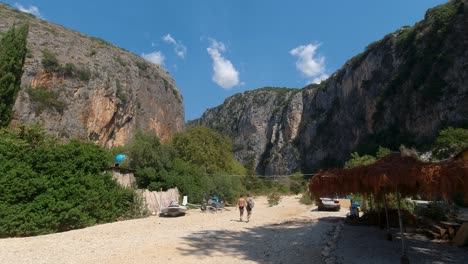Two-beach-goers-walking-towards-Gjipe-Canyon-in-Albanian-in-summer