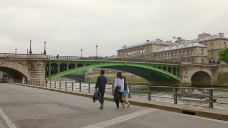Menschen,-Die-Auf-Der-Autofreien-Route-Am-Rechten-Ufer-Der-Seine-In-Paris,-Frankreich,-Mit-Pont-Notre-dame-Im-Hintergrund-Spazieren-Gehen