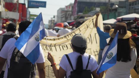 Salvadorianische-Spaziergänge-Mit-Nationalflaggen-Während-Eines-Friedlichen-Protestes-In-Den-Straßen-Der-Stadt-Gegen-Den-Derzeitigen-Präsidenten-Nayib-Bukele---Zeitlupe