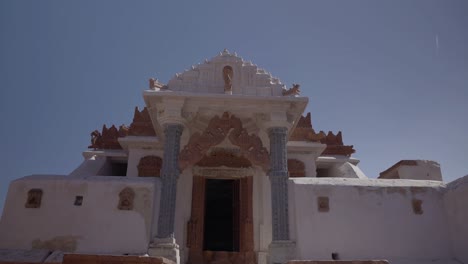 POV-Walking-Through-Metal-Gates-View-Of-Jain-Temple-In-Nagarparkar,-Pakistan
