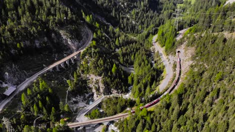 Aerial:-red-train-in-mountainous-landscape