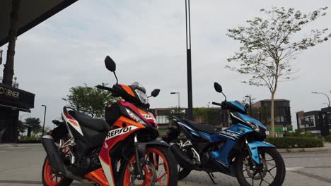 Malaysia,-Kuala-Lumpur,-12.-März-2022---Eine-Atemberaubende-Ausstellung-Von-Zwei-Honda-motorrädern-In-Leuchtenden-Blauen-Und-Orangefarbenen-Farben