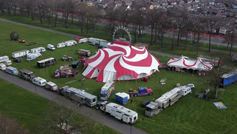 Planet-circus-daredevil-entertainment-colourful-swirl-tent-and-caravan-trailer-ring-aerial-rising-tracking-view