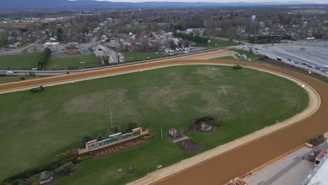 Aerial-view-following-Horses-competing-at-a-race-track-in-Charles-town,-United-states