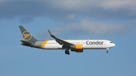 Tracking-shot-of-Condor-airways-passenger-plane,-descent-in-clear-sky-towards-airport