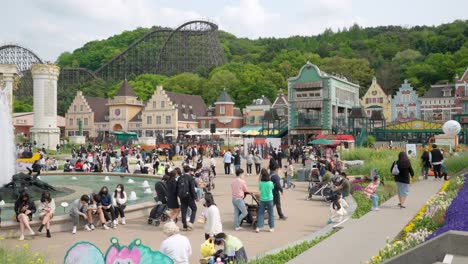 Family,-Friends,-And-Tourists-Visit-The-Famous-Everland-Theme-Park-With-T-Express-Roller-Coaster-Ride-In-the-Distance---wide