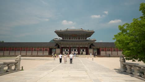 Touristen-In-Schutzmasken-Besichtigen-An-Einem-Klaren-Himmelstag-In-Der-Nähe-Des-Geunjeongmun-tors-Im-Gyeongbokgung-palast