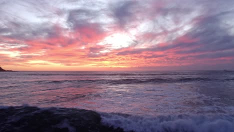 Premium Photo  A sunset over a beach with a pink sunset and the ocean.