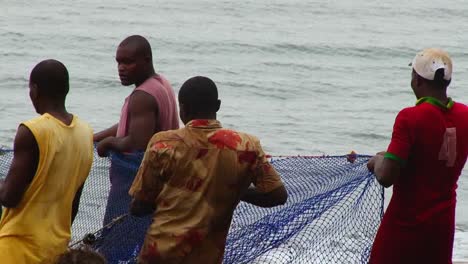 Vier-Afrikanische-Fischer-Ziehen-Nach-Einem-Angeltag-Die-Fischernetze-Am-Strand---Nahaufnahme