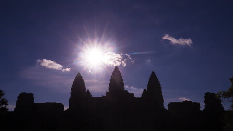 Angkor-Wat-silhouette-with-star-sun-and-fluffy-clouds,-zoom-out