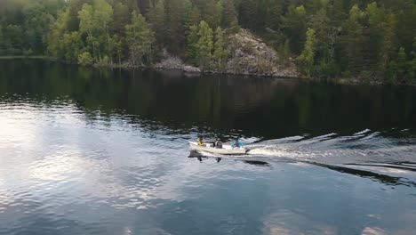 Eine-Gruppe-Von-Erwachsenen-In-Einem-Boot,-Das-Durch-Einen-Ruhigen-See-In-Der-Finnischen-Seenplatte-Fährt