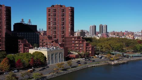 Long-stationary-drone-shot-of-apartment-highrise-buildings-in-Harlem,-Manhattan,-NYC-along-the-Harlem-River