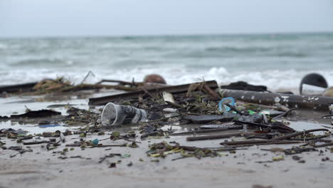 Sehr-Verschmutzter-Und-Schmutziger-Strand-Voller-Plastik-Und-Trümmer-Auf-Dem-Sand-Und-Im-Wasser-Entlang-Der-Küste