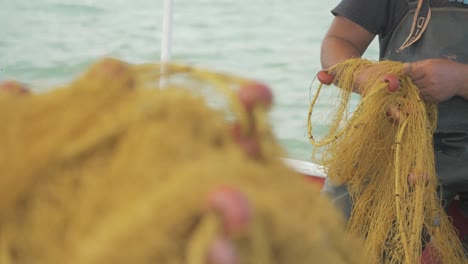 Greek-fisherman-traditionally-sorts-fishing-nets-by-hand-SLOW-MOTION