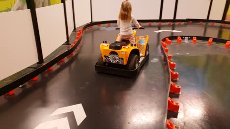Lustiger-Clip-Eines-Mädchens,-Das-Zufällig-Spielzeugauto-Im-Indoor-Vergnügungspark-Fährt
