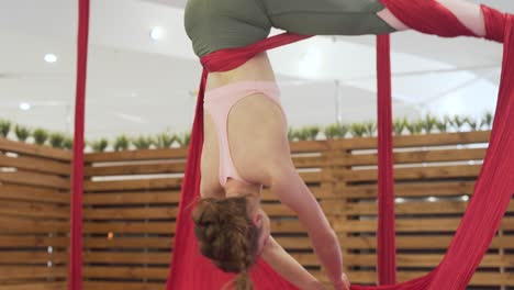 Schönes,-Fittes-Mädchen-In-Engen-Leggins-Und-Rosafarbenem-Oberteil,-Das-Fliegen-Yoga-Fitness-Praktiziert