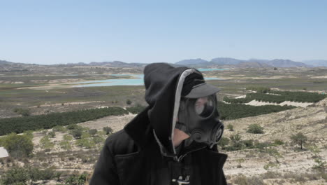 A-man-in-a-gas-mask-wanders-through-the-post-apocalyptic-desert-wasteland