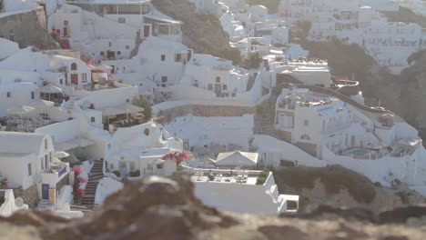 View-from-above-of-holiday-villas-and-rooms-in-the-traditional-cycladic-greek-village-of-Oia,-Santorini