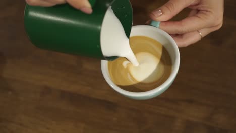 SLOWMO---Professional-female-barista-makes-tulip-in-cappuccino---close-up