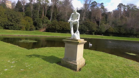 beautiful-artistic-white-historical-statue-establishing-shot-of-the-thinker-with-swan-in-the-background-park-lakes