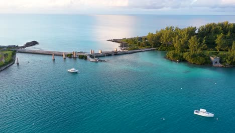Aerial-view-of-small-bridge-over-clear-turquoise-water-on-tropical-island