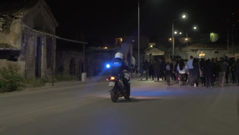 Police-biker-drives-behind-group-of-Greek's-walking-on-Easter