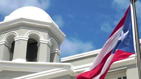 Bandera-Puertorriqueña-Ondeando-En-El-Viento-Frente-A-Un-Edificio-Del-Gobierno