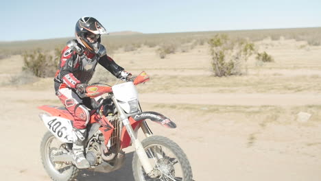 SLOW-MOTION:-A-dirt-biker-rides-his-CRF-Honda-through-the-desert-from-left-to-right