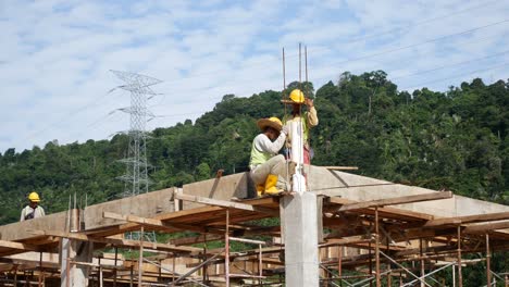 Construction-workers-installing-timber-form-works-and-rain-water-down-pipes-at-the-construction-site