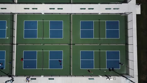 Drone-shot-directly-above-people-playing-on-four-pickle-ball-courts