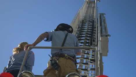 Feuerwehrleute-Bedienen-Eine-Lange-Rettungsleiter-Auf-Einem-Feuerwehrauto