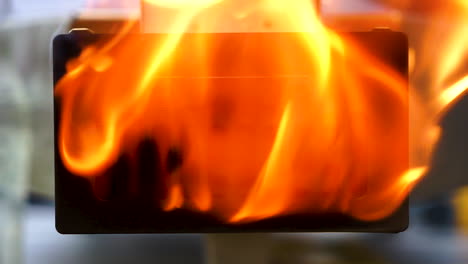 Slow-motion-hand-held-shot-of-a-yellow-flame-firing-out-the-back-of-a-table-top-pizza-oven,-flame-coming-out-of-a-grill