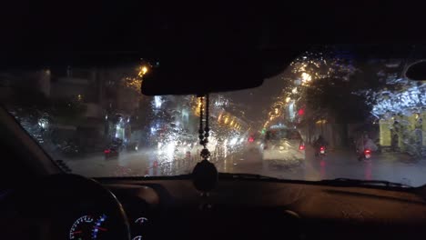 View-through-Taxi-window-in-pouring-tropical-rain-at-night-with-the-dazzling-lights-of-Ho-Chi-Minh-City-on-Saturday-night