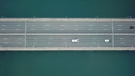 Aerial:-Birds-Eye-view-drone-shot-of-cars-and-one-cyclist-driving-across-Captain-Cook-Bridge-in-Sydney,-Australia