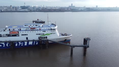 Stena-Line-freight-ship-loading-cargo-from-Wirral-terminal-Liverpool-aerial-view-tracking-Mersey-ferry