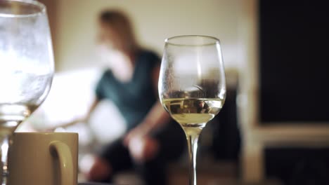 Glas-Weißwein-Und-Mädchen-Genießen-Hausparty-Im-Hintergrund