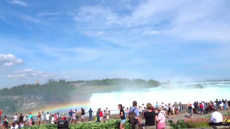 Stunning-panning-shot-of-tourists-walking-by-Niagara-Falls