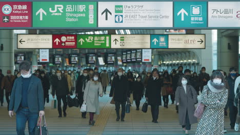 Eine-Fixierte-Aufnahme-Von-Menschen-Mit-Gesichtsmasken,-Die-Während-Einer-Pandemie-In-Tokio,-Japan,-Am-Bahnhof-Shinagawa-Pendeln