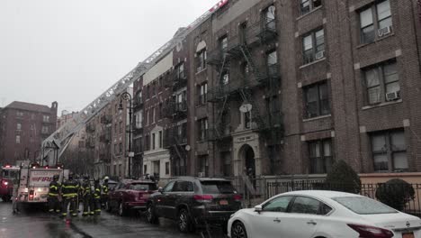 Firefighters-rooftop-rescue-with-fire-truck-ladder-at-ConEd-power-cable-fire-in-Brooklyn,-NYC---Wide-tilt-down-shot