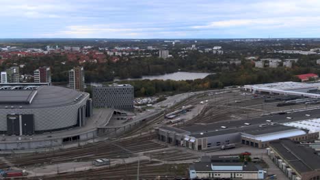 Aerial-pan-left-to-Friends-Arena,-Stockholm-And-Rail-Tracks-In-Foreground