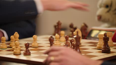 Nahaufnahme-Eines-Schachbretts,-Während-Geschäftsleute-Schnellschach-Darauf-Spielen